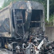Burnt out lorry that was completely destroyed by a fire on the hard shoulder of the M25 - delays continue.
