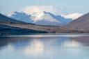 The snow-covered peak of Beinn Eighe and the mountains of Torridon are reflected in Loch Glascarnoch near Ullapool, Wester Ross. (Jane Barlow/PA)