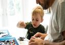 A young builds some Lego with his dad at home
