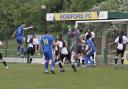Romford faced a packed Halstead defence as Hassan Nalbant wins a header. Picture: ALAN BLACKHOLLY