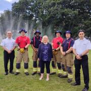 Fiona Twycross (centre) and members of the LFB in front of the holey hose.