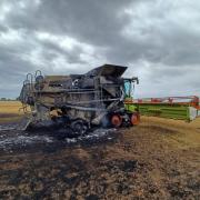 A charred combine harvester following a fire near Hainault Country Park