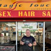 Maciej Sosnowski celebrates with the award outside his hairdressers Magic Touch