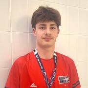 Kai proudly faces the camera with his MC 100m breaststroke bronze medal