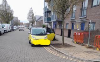 A car parked on yellow lines outside the school